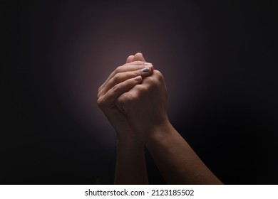 Praying hands with faith in religion and belief in God over dark background - Shutterstock ID 2123185502