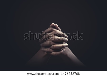 Praying hands with faith in religion and belief in God on dark background. Power of hope or love and devotion.