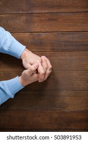 Praying hands of man on wooden desk - Shutterstock ID 503891953
