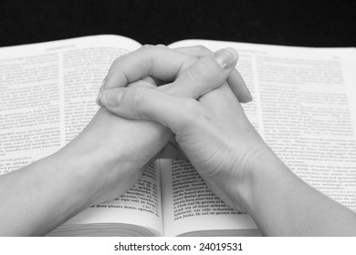 Praying Hands On An Open Bible