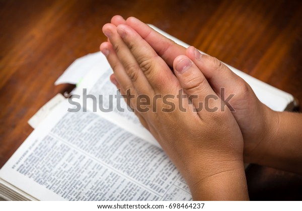 Praying Hands Over Bible Stock Photo 698464237 Shutterstock