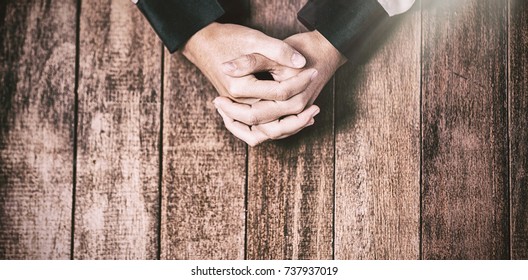 Praying hands of woman on wooden table