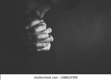 Praying man hoping for better. Asking God for good luck, success, forgiveness. Power of religion, belief, worship. Holding hands in prayer, eyes closed.