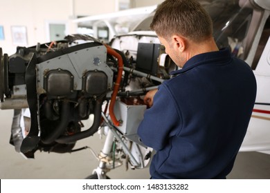 Pre Flight Check Or Maintenance On A Small Aircraft In A Hangar