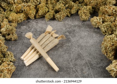 pre rolled marijuana joints surrounded by pile of weed