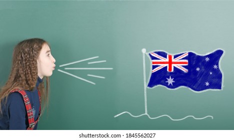 Pre-adolescent Girl Blowing On The School Board Drawn On The Blackboard Australia Flag. High Resolution Photo. Full Depth Of Field. 