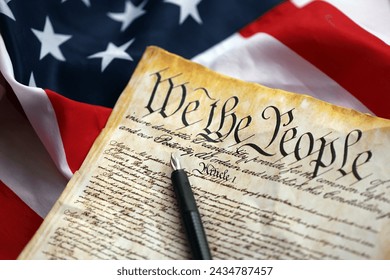 Preamble to the Constitution of the United States and American Flag. Old yellow paper with We The People text - Powered by Shutterstock