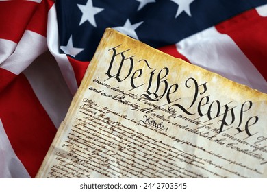 Preamble to the Constitution of the United States and American Flag. Old yellow paper with We The People text - Powered by Shutterstock