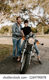 Precious Cute Leisure Lifestyle Portrait Of Handsome Guy And Girl Beauty Being Silly Fun And Laughing While Riding Classic Motorcycle Bike While In Love