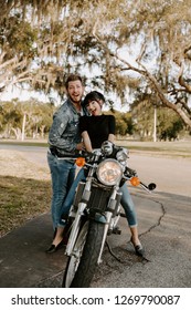 Precious Cute Leisure Lifestyle Portrait Of Handsome Guy And Girl Beauty Being Silly Fun And Laughing While Riding Classic Motorcycle Bike While In Love