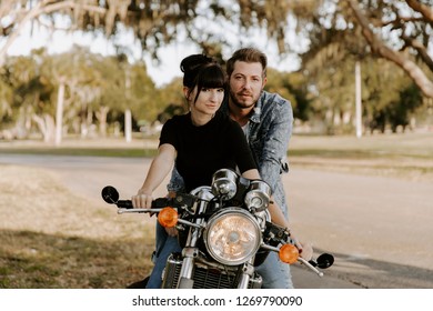 Precious Cute Leisure Lifestyle Portrait Of Handsome Guy And Girl Beauty Being Silly Fun And Laughing While Riding Classic Motorcycle Bike While In Love