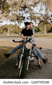 Precious Cute Leisure Lifestyle Portrait Of Handsome Guy And Girl Beauty Being Silly Fun And Laughing While Riding Classic Motorcycle Bike While In Love