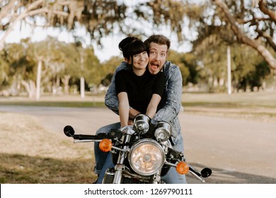 Precious Cute Leisure Lifestyle Portrait Of Handsome Guy And Girl Beauty Being Silly Fun And Laughing While Riding Classic Motorcycle Bike While In Love