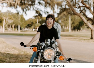 Precious Cute Leisure Lifestyle Portrait Of Handsome Guy And Girl Beauty Being Silly Fun And Laughing While Riding Classic Motorcycle Bike While In Love