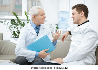 Precious Experience. Senior Male Doctor Talking To His Young Intern At The Hospital Internship Education Industry Experience Healthcare Specialist Seniority Medicine Therapist Communication Concept