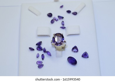 Precious Gift For Your Lover. Amethyst Gemstone Ring And Violet Or Purple Loose Stone On White Background. Gems And Jewellery Background       