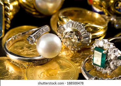 Precious jewels, rings with diamonds, emeralds and corals on pounds in gold - Powered by Shutterstock