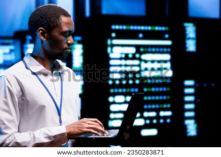 Precise engineer inspecting blade servers performing data backups and providing centralized storage. African american specialist maintenancing electric generators ensuring operational continuity