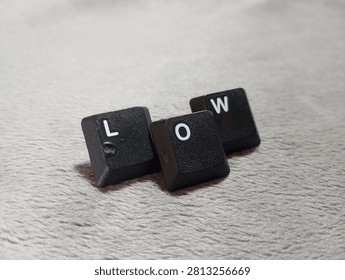 A precise high-angle shot of keyboard letters arranged to spell LOW, emphasizing the clean lines and modern typeface used in computer peripheral hardware design. This studio-quality image highlights the aesthetic of mechanical keycaps on a light background, perfect for tech-focused projects. The lighting is balanced to show the texture of the plastic, creating a professional look suitable for commercial advertising, websites, or editorial publications. By focusing on the simplicity of the hardware, the image conveys efficiency and modern functionality. It is an ideal visual for articles on computer hardware, digital workspaces, or minimalist branding. With its sharp focus and clean layout, this photo is ready to be used in various professional contexts, providing a clear and impactful message through the clever arrangement of everyday office equipment and classic computer technology.