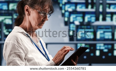 Precise system administrator in data center equipped to handle complex computing operations, doing regular upgrades to server parts, increasing processing power to prevent collapse