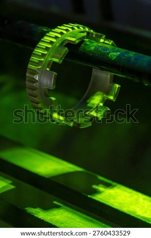 Precision aircraft engine component glowing in vivid fluorescent green light during magnetic particle non-destructive inspection in an aerospace maintenance workshop. Aerospace quality control crack detection