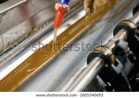 Precision application of glue using advanced machinery for seamless adhesion in manufacturing processes