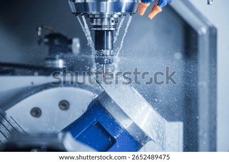 Precision cnc milling machine in action with cooling fluid.