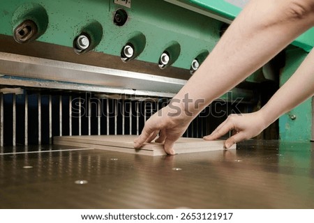 Precision cutting of cardboard sheets using guillotine shears in a modern workshop