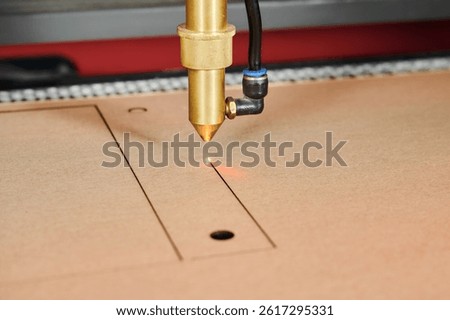 Precision laser cutting transforms cardboard sheets in a busy manufacturing environment at a box production facility