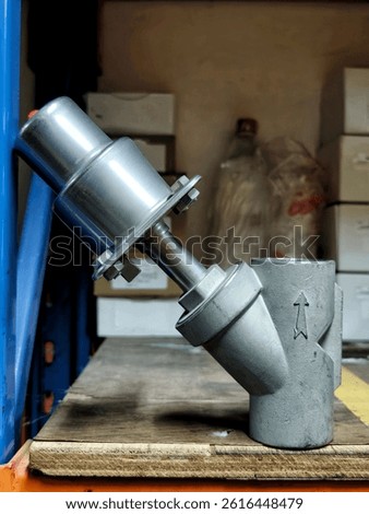 A precision-engineered valve system positioned on a wooden table, serving as an essential tool for fluid flow control in industrial machinery.