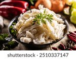 Precooked beef tripes in a bowl with vegetables and herbs ready for cooking.