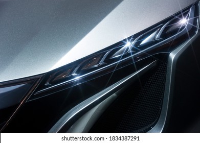 Predatory car headlight of powerful sports vehicle with grey bodywork, automobile industry