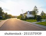 Prefab house. Street in residential area. Contemporary Residence in suburb. Rows of modern houses along road. Family house, Modern Home outside city. Trees, green lawn at Villa. Modern barnhouse.