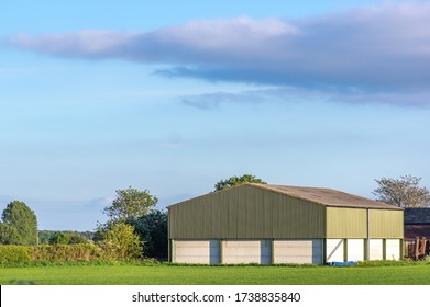 Prefabricated Farm Building In A Rural Setting On A Sunny Day With Blue Sky.