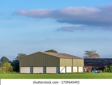 Prefabricated Farm Building In A Rural Setting On A Sunny Day With Blue Sky.