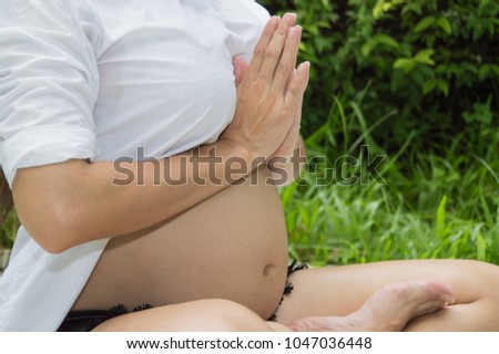 Pregnancy care concept. Pregnant women are exercising with yoga. Beautiful girls are hoping the future of the baby in the womb. Pregnant women are taking care of their health. Stock photo © 
