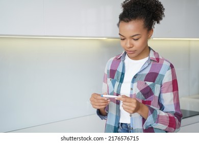 Pregnancy Checking Home Test. African American Teenage Girl Gets Pregnancy Test Result. Satisfied Young Spanish Woman Is Looking At The Stripes. Baby Planning And Contraception Concept.