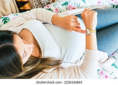 Pregnancy contractions time. Childbirth time, contractions pain. Pregnant holding baby belly, woman watching clock. Therapy, healthcare, motherhood concept - Shutterstock ID 2236146865