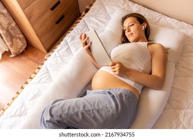 Pregnancy digital tablet. Pregnant woman holding digital tablet. Mobile pregnancy online maternity application. Concept of pregnancy, maternity, expectation for baby birth