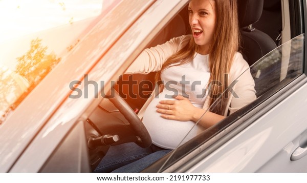 Pregnancy driving\
car. Young beautiful pregnant woman driving car. Safety pregnancy,\
mother health care\
concept