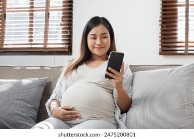 Pregnancy Enjoying Technology and comfortable at Home, Natural Light Through Window Blinds, Casual Maternity Lifestyle - Powered by Shutterstock