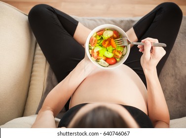 Pregnancy And A Healthy Diet. Close Up Pregnant Woman At Home Eating A Healthy Green Salad.