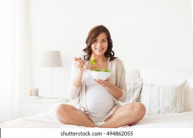 Pregnancy, Healthy Food And People Concept - Happy Pregnant Woman Eating Vegetable Salad For Breakfast At Home