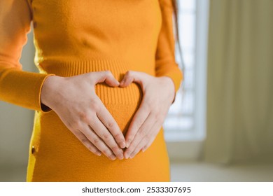 Pregnancy motherhood expectation future. Pregnant woman hands touching big belly. Girl making heart shape with hands enjoying pregnancy. Pregnant woman showing heart sign. Maternity love new life - Powered by Shutterstock