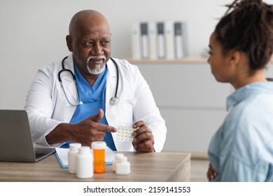 Pregnancy, Obstetrics And Gynaecology People Concept. Professional Senior African American Male Gynecologist Giving Pills To Pregnant Lady During Appointment At Hospital, Future Mom Visiting Doctor