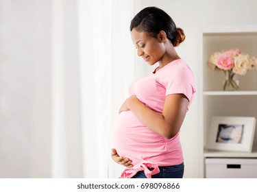 pregnancy, people and expectation concept - happy pregnant african american woman with big belly at home