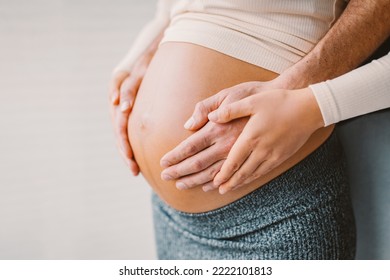 Pregnancy photo man and woman holding pregnant bump expecting baby. Happy family hands on stomach closeup. Couple in love. - Powered by Shutterstock