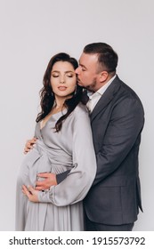 Pregnancy Photoshoot Of A Beautiful Couple, Future Parents In A Gray Dress And Suit