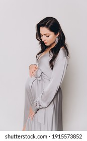 Pregnancy Photoshoot Of A Beautiful Couple, Future Parents In A Gray Dress And Suit