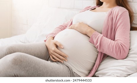 Pregnancy and rest. Young millennial pregnant woman lying in bed, panorama with free space